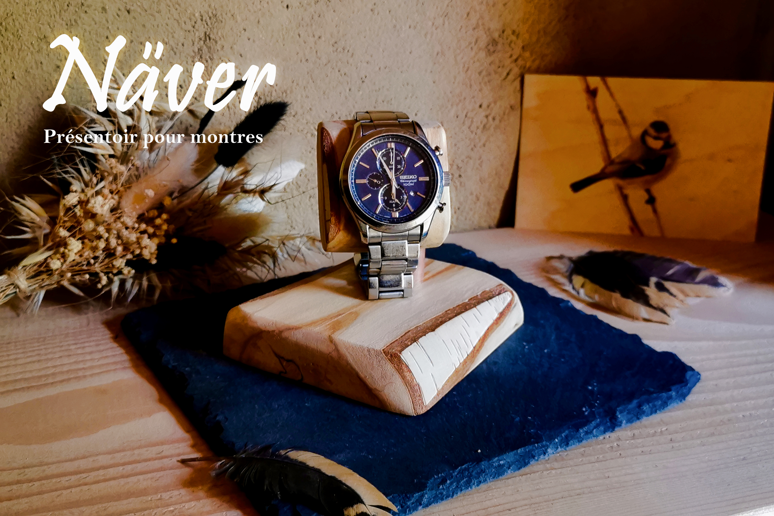 Vue avec montre du présentoir Näver en bois de bouleau massif avec son écorce préservée. Image filigranée avec le nom commercial du présentoir.